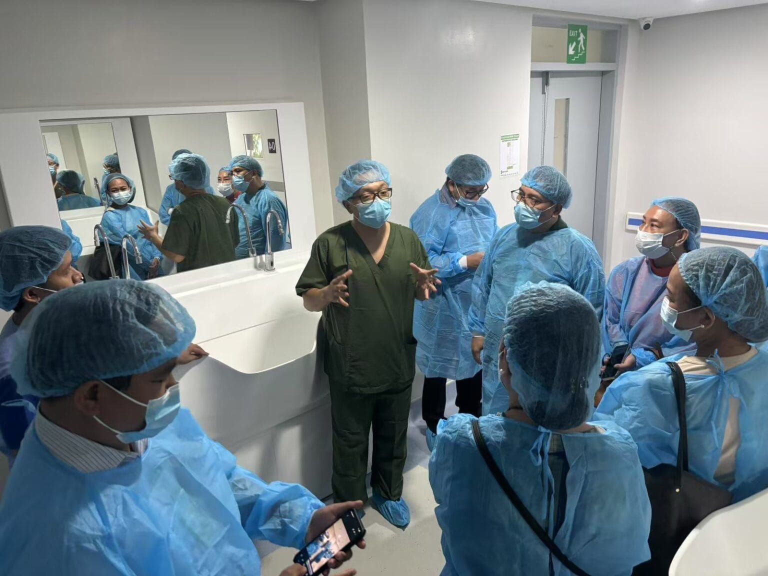 Medical professionals gathered at the solid surface surgical sink in JBLMGH new Trauma and Orthopedic building