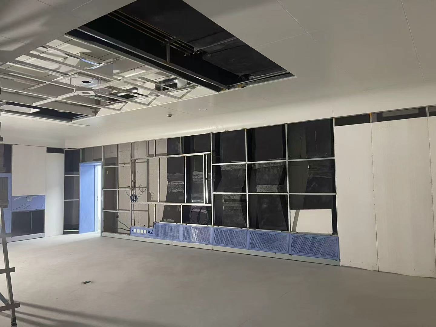 Modular operating room under construction showing wall panel installation and clean zone boundary before finishing