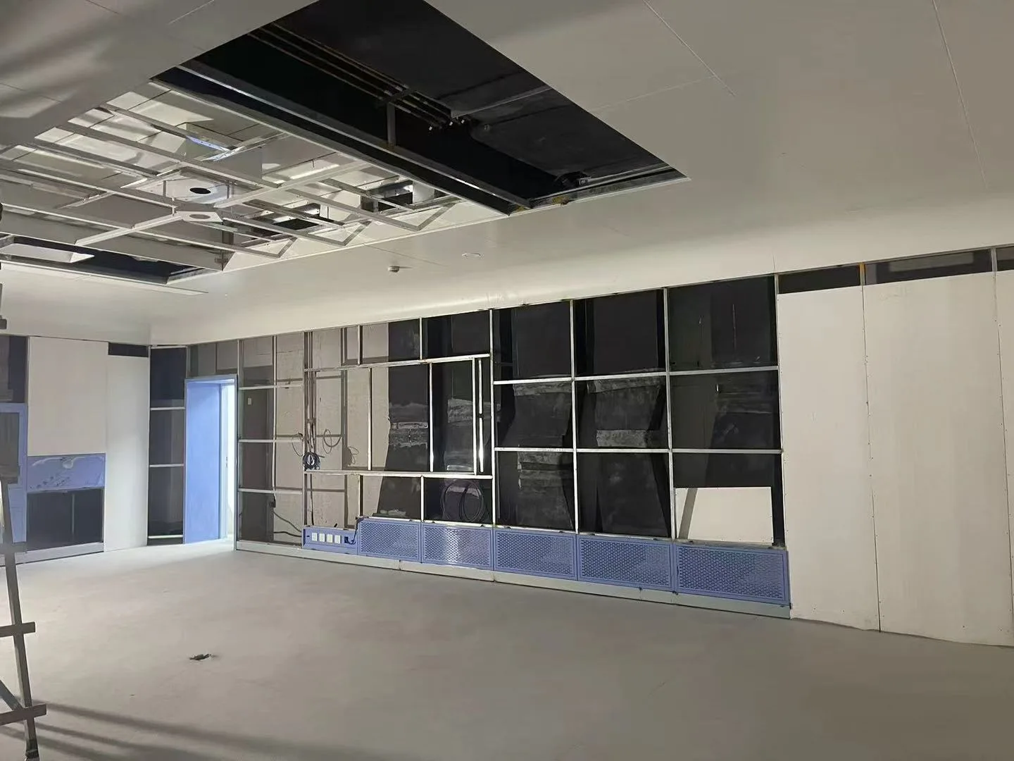 Quirófano modular en construcción que muestra la instalación de los paneles de pared y el límite de la zona limpia antes de su finalización.