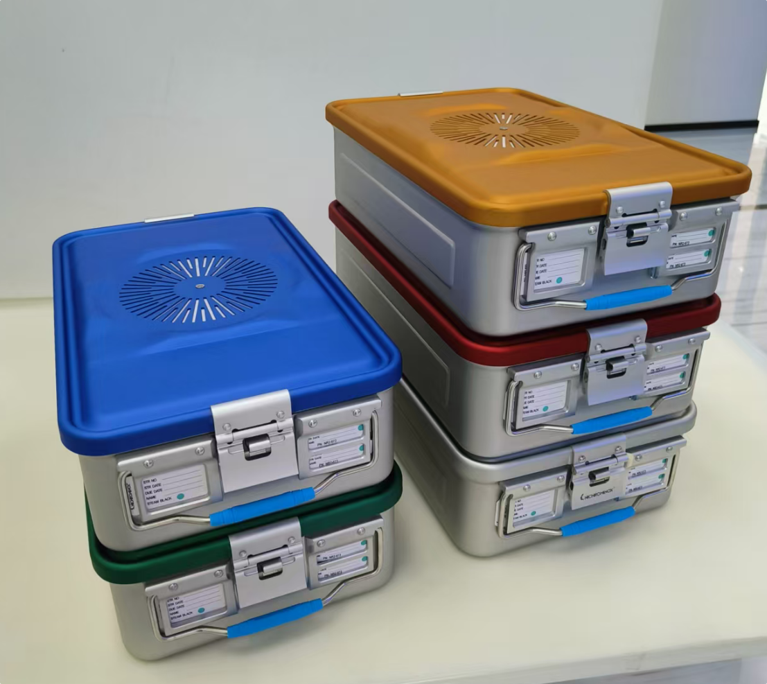 Stacked sterilization containers with colorful lids on table.