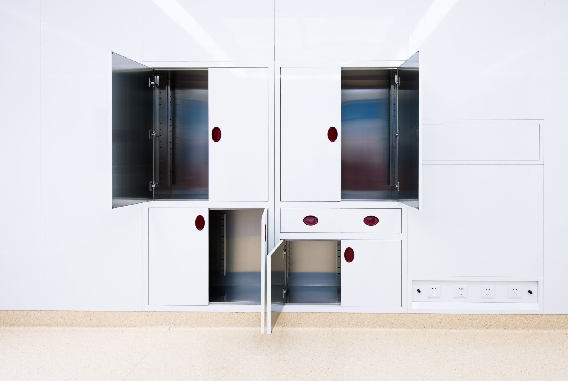 White cabinets with open doors and drawers in icarelife modular operating theater