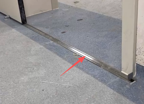 Recessed automatic rising floor threshold channel installed at a radiology room sliding lead door