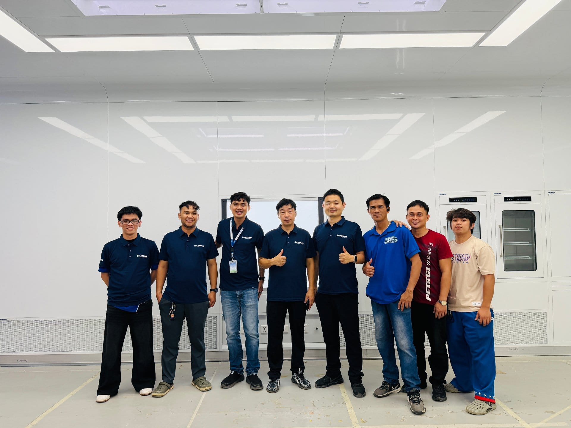 Full project team in front of glass wall at completed Quezon City showroom