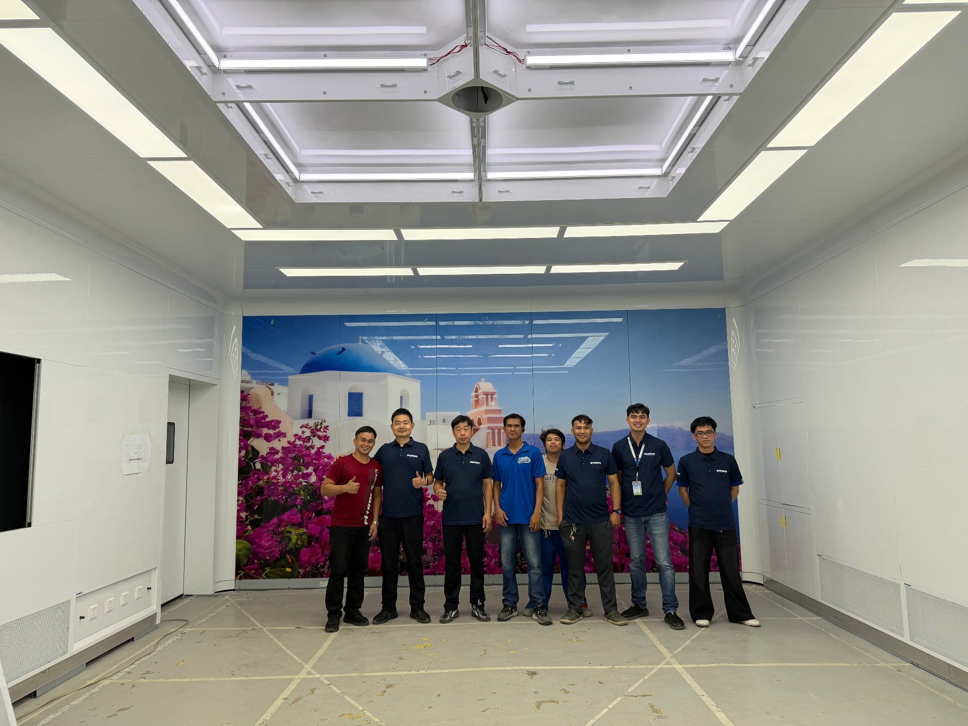 ICARELIFE and partner team in front of printed glass mural wall in finished OR