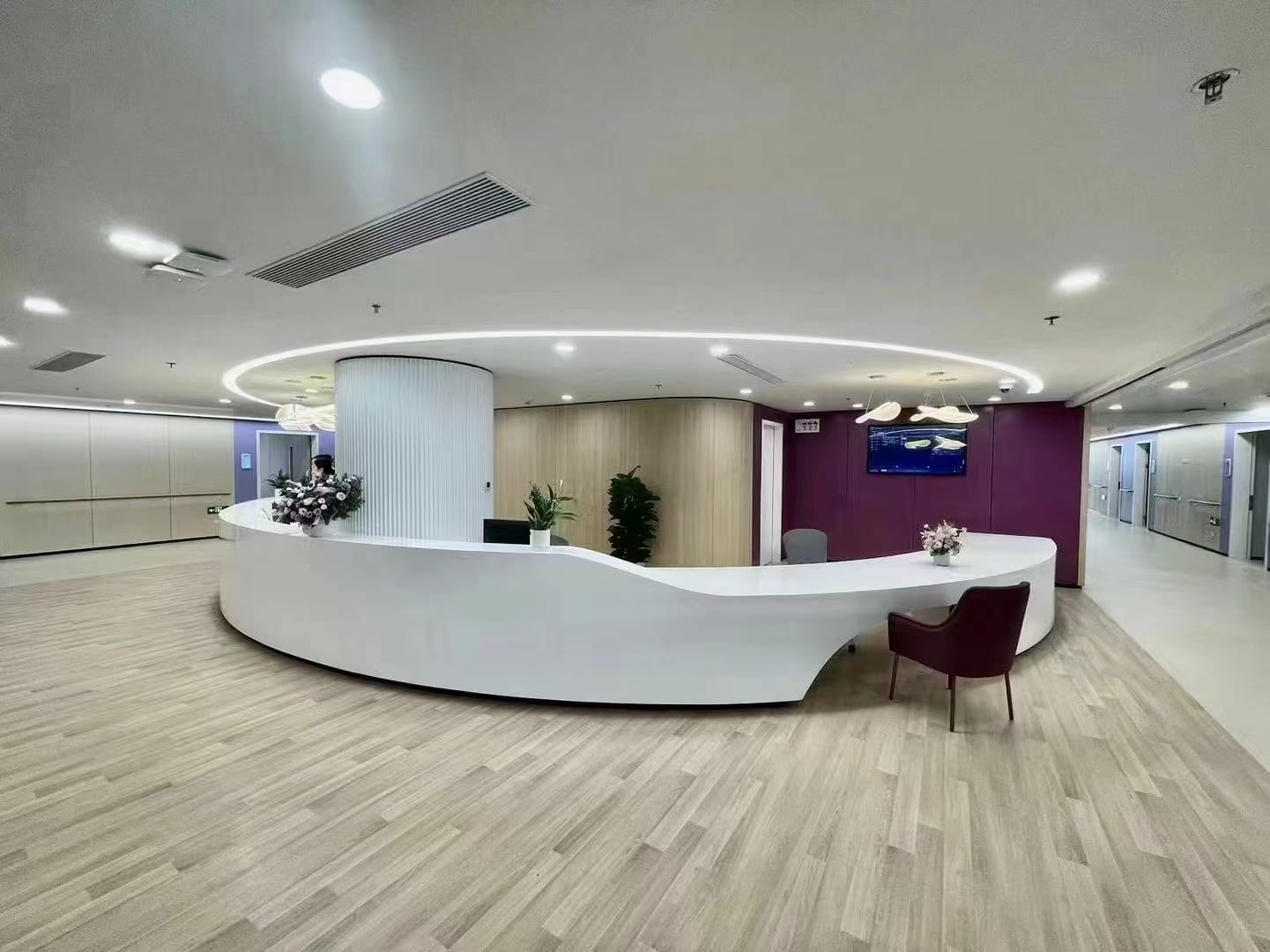 Curved white nurse station and reception counter in a hospital lobby