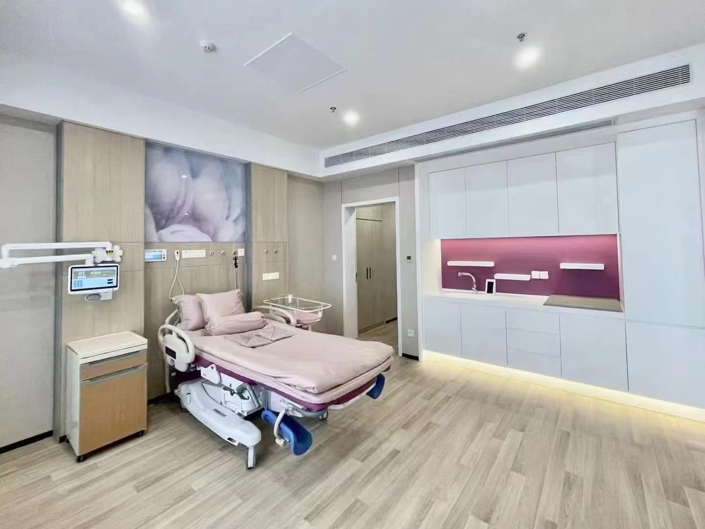 Patient room with a wall unit of storage cabinets and a recessed work niche
