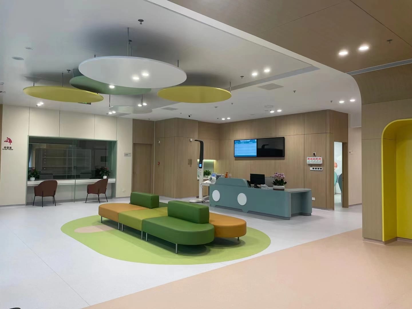 Pediatric waiting area with a reception desk and colored seating
