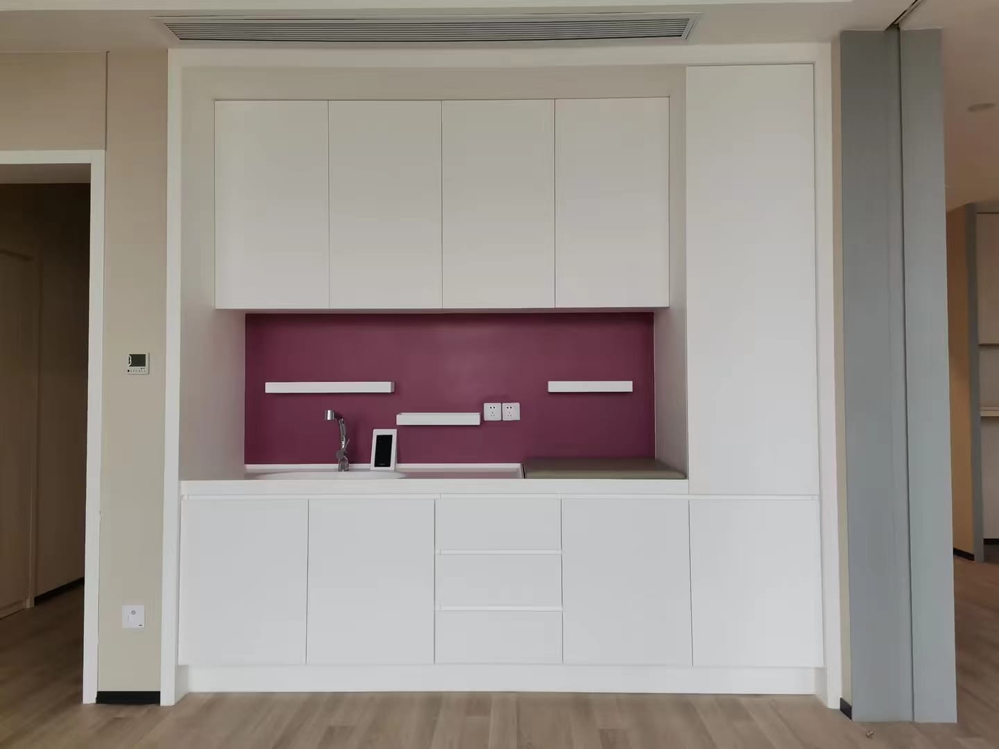 Wall cabinet with an integrated sink and a colored backsplash panel